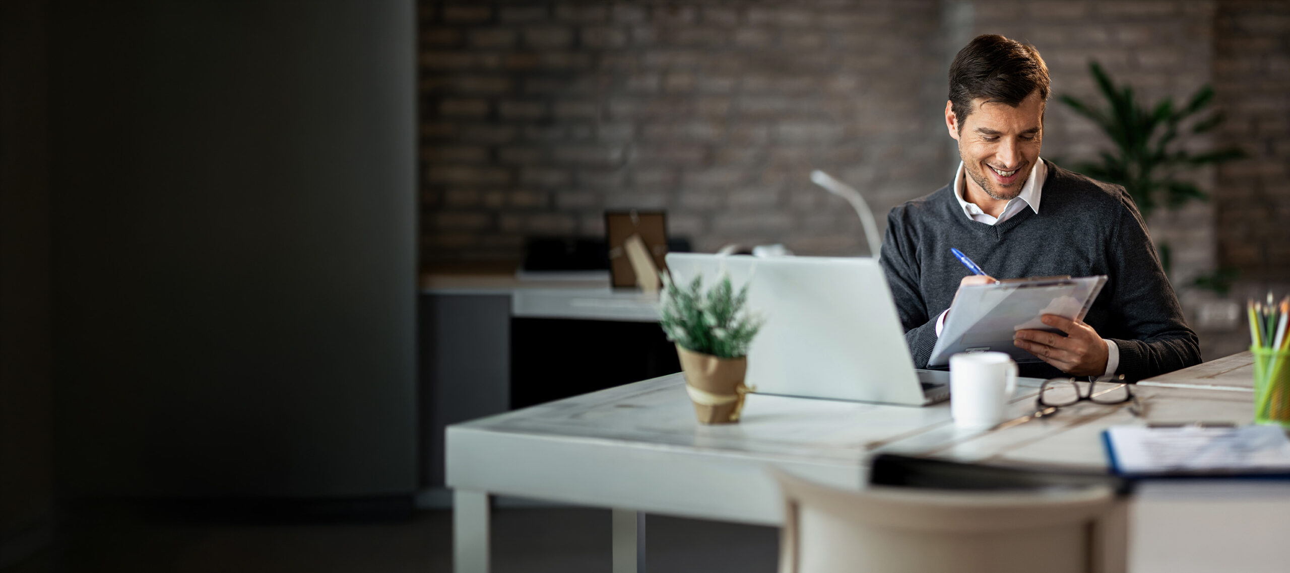 Advisor smiling while working at a laptop