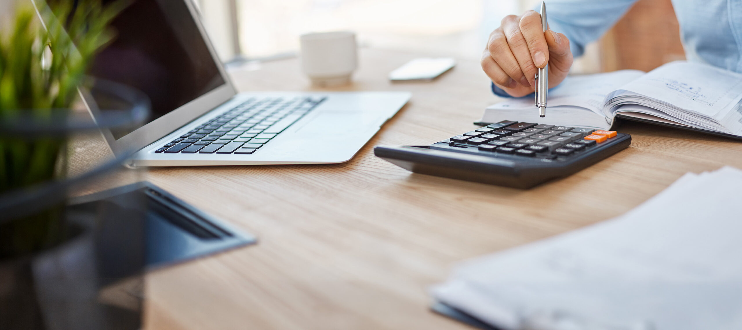 Calculator and laptop on a desk